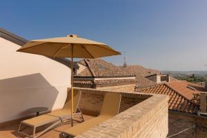 a patio with two chairs and an umbrella at Bed and breakfast Piazza Piè di Corte in Corropoli