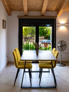 ein Esszimmer mit einem Tisch und gelben Stühlen in der Unterkunft Casa Rural Paseo de cuento in Villarquemado