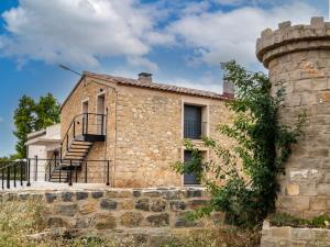 ein altes Steinhaus mit einem Turm in der Unterkunft Casa Rural Paseo de cuento in Villarquemado