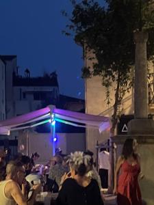a group of people sitting outside at a party at night at La Belle Vue in Ganges