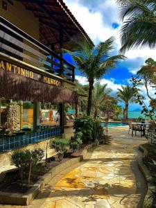 a resort building with a swimming pool and palm trees at SR Sunset in São Sebastião