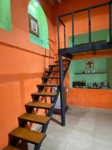 eine Treppe in einem Zimmer mit orangefarbener Wand in der Unterkunft Espacio privado muy cerca del centro in Guanajuato + 13 Fotos