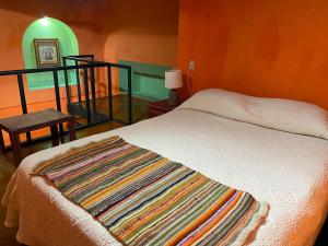 ein Schlafzimmer mit einem Bett und einem Tisch mit einer Lampe in der Unterkunft Espacio privado muy cerca del centro in Guanajuato