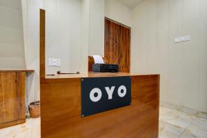 a sign on a counter in a room with a pay phone at SPOT ON Manjuvilla in Varanasi