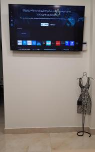Un maniquí frente a un televisor en una pared. en JASMIN Luxury Apartment, en Atenas