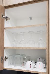 Un armario lleno de copas de vino y platos. en JASMIN Luxury Apartment, en Atenas