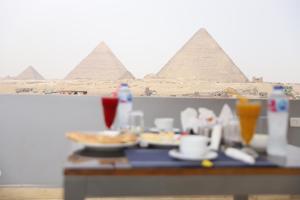 a table with plates of food in front of the pyramids at Pyramids Motel in Cairo