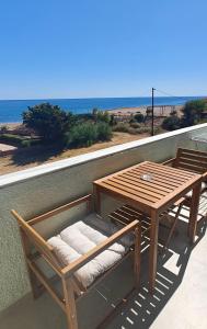 a wooden table and chairs on a balcony with the ocean at Locanda in Monemvasia +25 photos