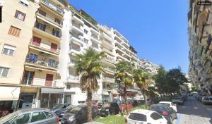 a street with cars parked in front of a tall building at Hippodrome Cute - Blue in Thessaloniki