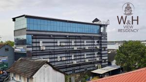 Un edificio alto y negro con un cartel. en W&H View Residency, en Kochi