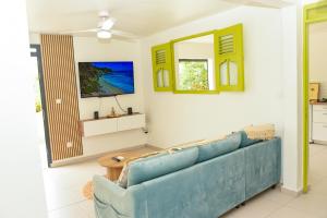 a living room with a blue couch and a ceiling fan at Lisalyne in Le Moule