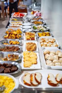 a buffet line of plates of food on a table at SWAMY HOTEL ANEXO I in Cruzeiro do Sul