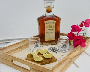 a tray with a bottle of whiskey and glasses and flowers at Lisalyne in Le Moule +21 photos