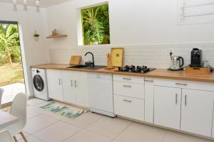 a kitchen with white cabinets and a sink and a stove at Lisalyne in Le Moule