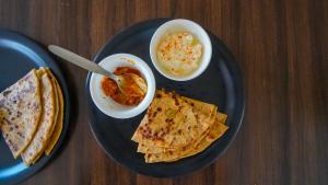 twee borden eten op een houten tafel bij Corbett Mid Forest House - 1Min Walk to River & Jungle Safari in Rāmnagar