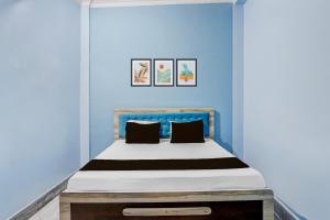 a blue bedroom with a bed with a blue wall at SPOT ON S Paradise in Patna