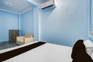 a blue bedroom with a bed and a air conditioner at SPOT ON S Paradise in Patna