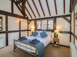 a bedroom with a bed with blue pillows on it at The Coach House in Church Stretton