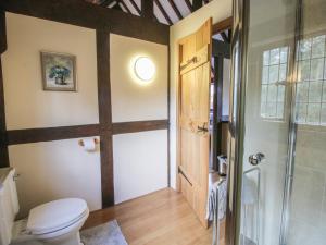 a bathroom with a toilet and a glass door at The Coach House in Church Stretton +30 photos