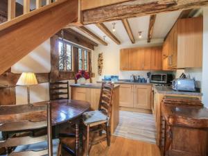a kitchen with wooden cabinets and a wooden table at Courtyard Cottage in Church Stretton +24 photos