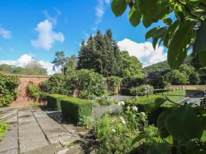 a garden with hedges and a brick wall at Courtyard Cottage in Church Stretton