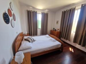 sypialnia z łóżkiem z białą pościelą i oknami w obiekcie Bay View House by MTH w Funchal