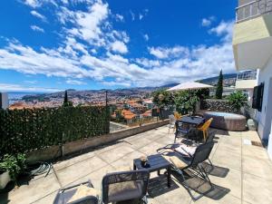 patio z krzesłami i stołami oraz widokiem na miasto w obiekcie Bay View House by MTH w Funchal