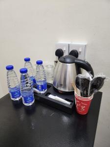a tea kettle and bottles of water on a counter at شقق العصر الماسي للشقق المفروشة - Al Asr almasi Suite Apartments in Al Madinah