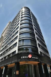 a tall building with a sign on it at Hotel R14 in Kaohsiung