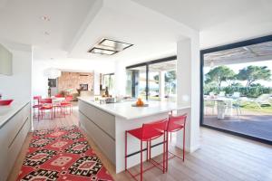 une cuisine avec des tabourets rouges et un comptoir blanc dans l'établissement Elegant 5 Bedroom Villa in Ibiza City, 1078, à Sant Josep