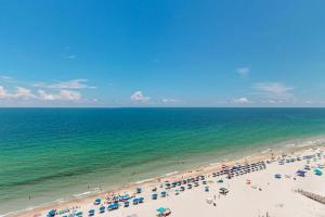 a beach with a lot of umbrellas and the ocean at Phoenix I 1142 in Orange Beach
