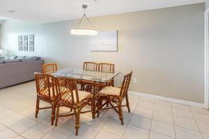 a dining room with a glass table and chairs at Phoenix I 1142 in Orange Beach