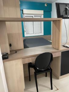 - un bureau avec une chaise et un bureau avec un ordinateur dans l'établissement JK prox Regina e Feevale com AC e espaço Home Office, à Novo Hamburgo