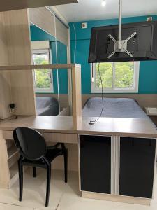 Cette chambre comprend un bureau avec une chaise et un lit. dans l'établissement JK prox Regina e Feevale com AC e espaço Home Office, à Novo Hamburgo