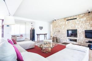 un salon avec un canapé blanc et une cheminée en pierre dans l'établissement Elegant 5 Bedroom Villa in Ibiza City, 1078, à Sant Josep