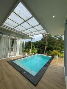 an indoor swimming pool in a house with a glass ceiling at Paradise Villa - 2BR - Private Pool - Peaceful Garden - 4K SmartTV in Thongsala