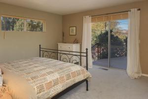 Un dormitorio con una cama y una puerta corrediza de vidrio. en Amazing Views in the Heart of West Sedona for Family, en Sedona