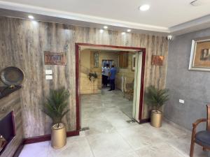 a hallway with a mirror and people in a room at Pyramids Motel in Cairo