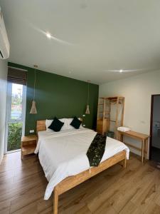 a bedroom with a large bed with a green wall at Paradise Villa - 2BR - Private Pool - Peaceful Garden - 4K SmartTV in Thongsala +28 photos