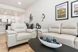 Northfield Old Town Flat with Attached Garage and EV في Buckingham: غرفة معيشة بها أريكتان باللون الأبيض ووعاء من البيض