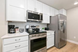 Northfield Old Town Flat with Attached Garage and EV في Buckingham: مطبخ بخزائن بيضاء وثلاجة من الفولاذ المقاوم للصدأ +20 صورة