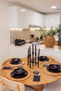 a wooden table with plates and glasses on it in a kitchen at Velora Stays Cozy Luxury Apartment in Reem Island in Abu Dhabi
