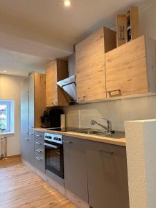 a kitchen with stainless steel appliances and wooden cabinets at Apartment Ana in Arzl im Pitztal +22 photos
