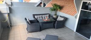 a patio with a table and wicker chairs at Suites & Gym by Karon Homes in Karon Beach