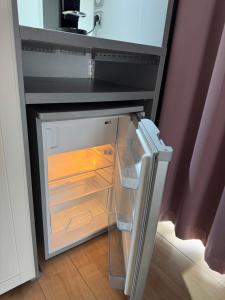 a small refrigerator with its door open in a kitchen at Résidence des Fleurs in Hombourg-Haut