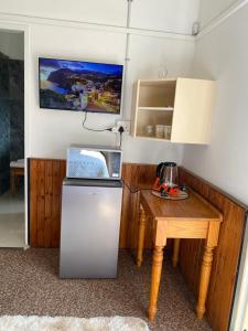 a small kitchen with a table and a refrigerator at Meadway Cosy retreat for 2 in Benoni
