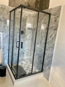 a shower with a glass door in a bathroom at Meadway Cosy retreat for 2 in Benoni