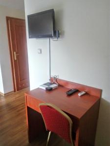 a desk with a television on a wall with a chair at Zacisze in Ulan