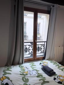 a bedroom with a bed and a window with a view at Elegant Studio near Pompidou Center in Paris