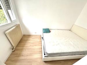 a small bedroom with a bed and a window at Spacious T3 appart nearby la defense & Arena in Puteaux